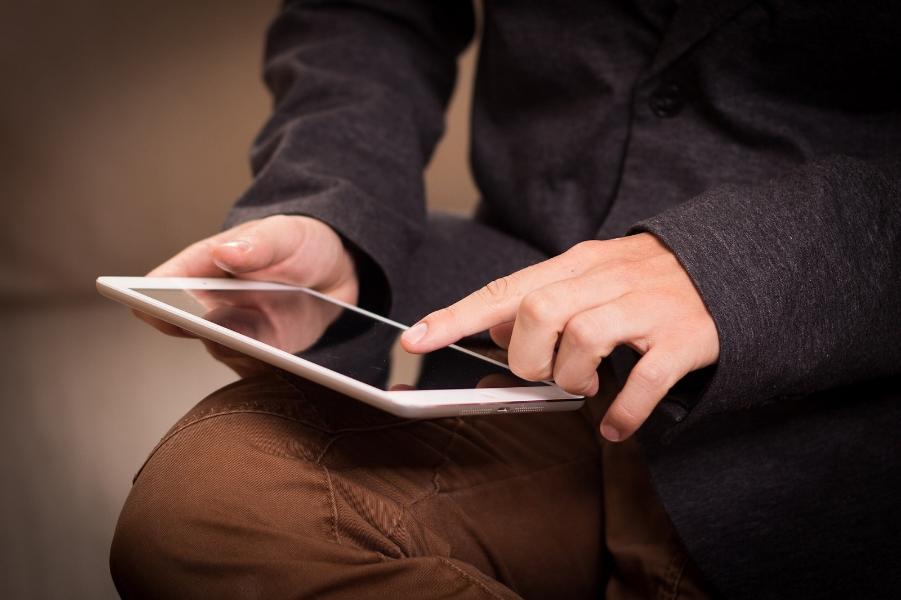 Digital Tablet A person sat with a tablet on their knee.