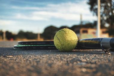 Tennis ball and bats on a tennis court.