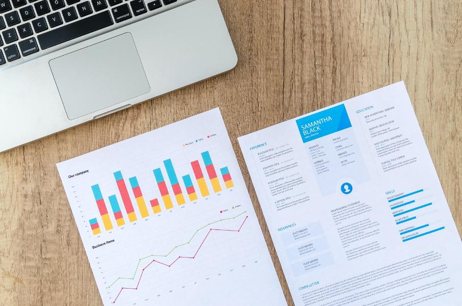 A CV and resume A CV and resume with a laptop on a table