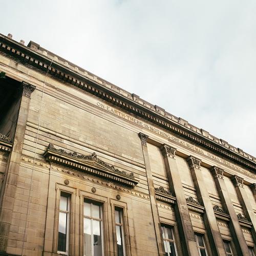 Side of the Harris building with inscriptions and decorative stonework.